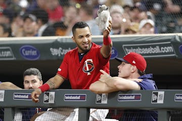 Minnesota Twins right fielder Eddie Rosario (20) holds the "rally squirrel" during the tenth inning.