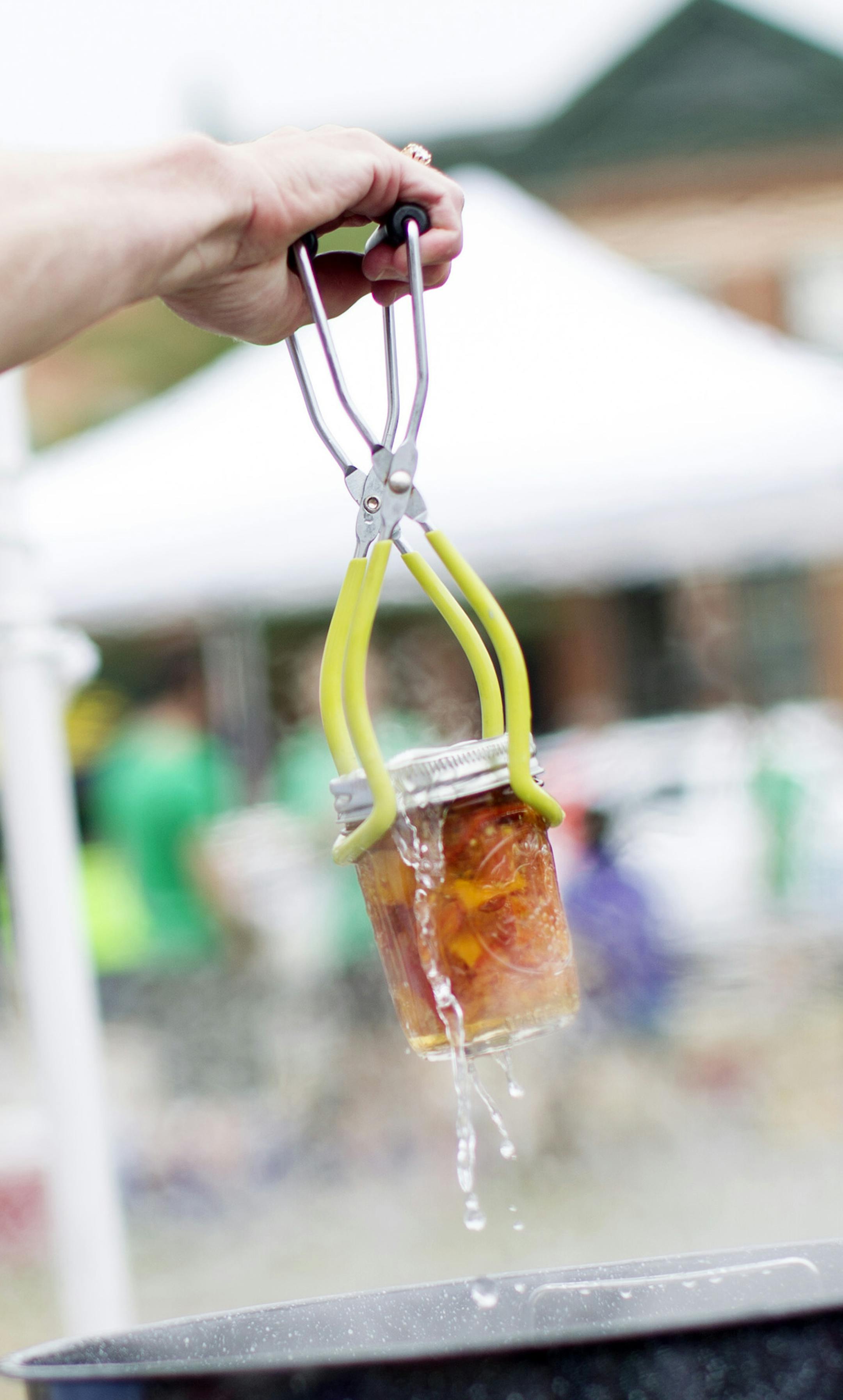 A freshly-sealed jar is removed from boiling water during a canning demonstration at the Urban Oasis Food Fest in St. Paul August 17, 2014. (Courtney Perry/Special to the Star Tribune)
