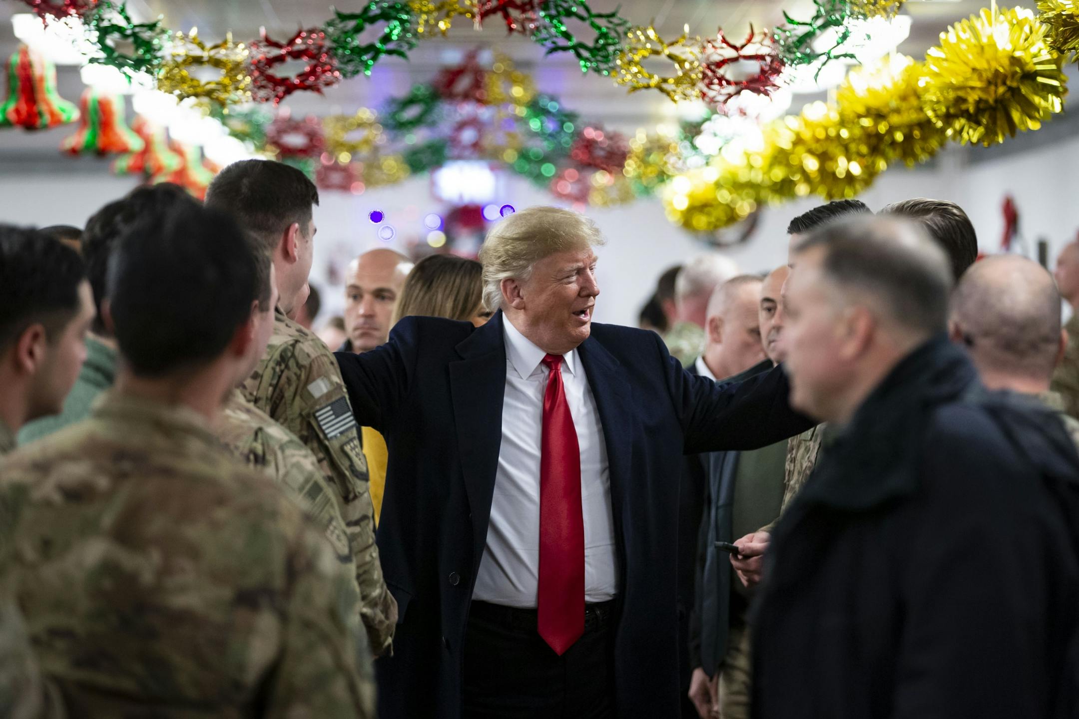 President Donald Trump with military personnel in a dining hall at the al-Asad Air Base in Iraq's Anbar province, Dec. 26, 2018. The surprise trip, which came in the midst of a government shutdown, was Trump's first visit to troops stationed abroad in a combat zone.
