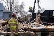 Firefighters investigate the scene of an explosion on the 6400 block of Oliver Avenue South that leveled the house in Richfield on Monday.