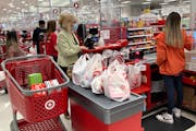 FILE - A customer wears a mask as she waits to get a receipt at a register in Target store in Vernon Hills, Ill., Sunday, May 23, 2021. Retail sales r