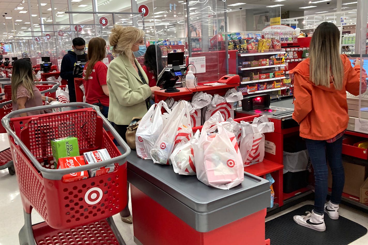 FILE - A customer wears a mask as she waits to get a receipt at a register in Target store in Vernon Hills, Ill., Sunday, May 23, 2021. Retail sales rose modestly in March 2022, but higher prices for food, gasoline and other basics took a big share of their wallet. Retail sales increased 0.5% after registering a revised 0.8% jump from January to February. (AP Photo/Nam Y. Huh, File)