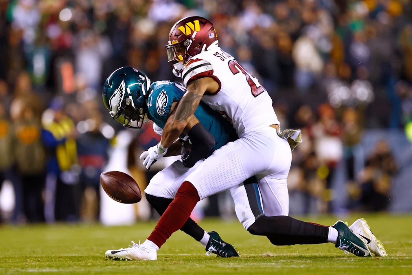 Philadelphia Eagles wide receiver Quez Watkins (16) makes a catch and fumbles the ball as Washington Commanders cornerback Benjamin St-Juste (25) makes the tackle during the fourth quarter of an NFL football game, Sunday, Nov. 14, 2022, in Philadelphia. The Commanders defeated the Eagles 32-21. (AP Photo/Rich Schultz)