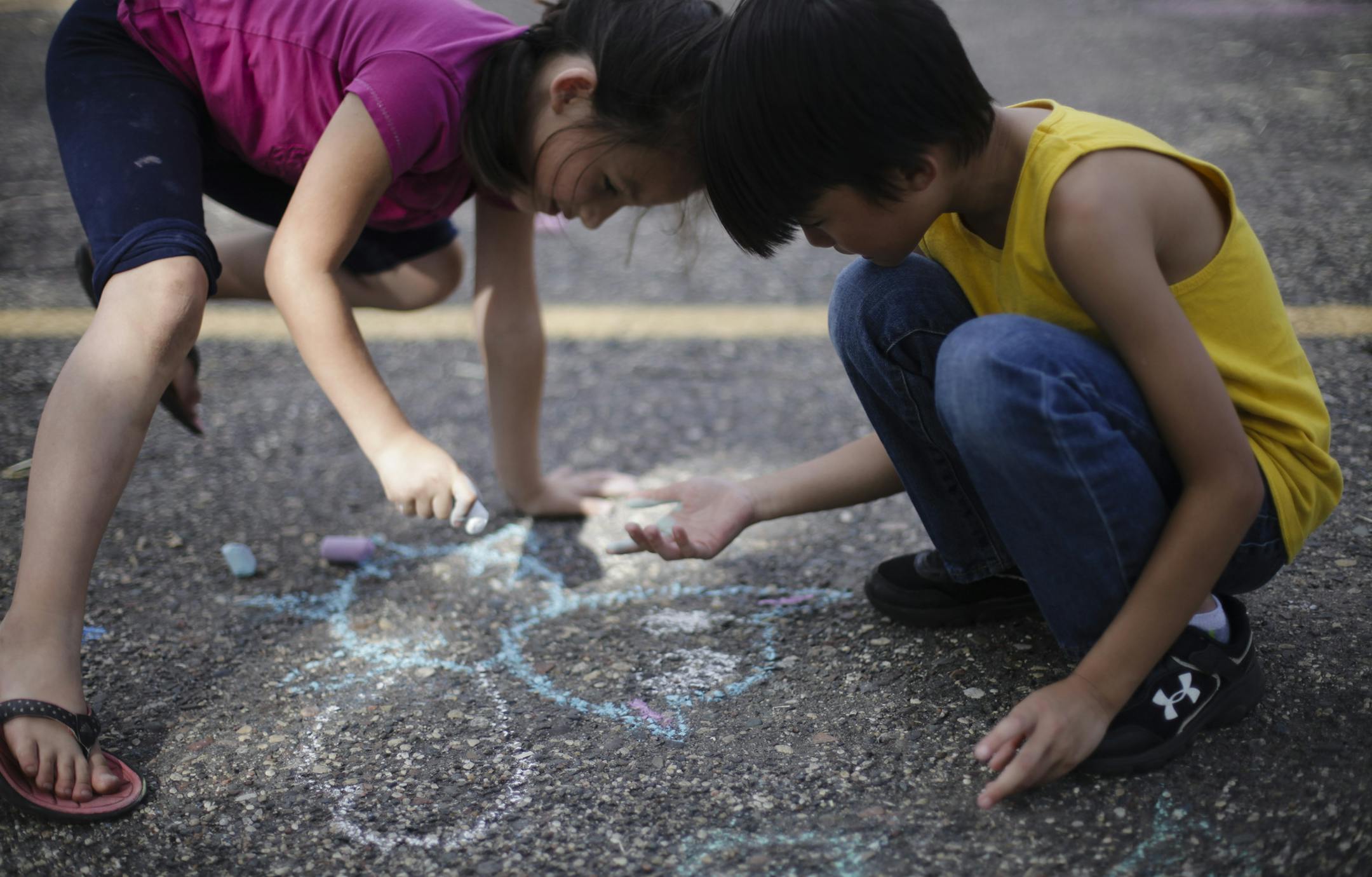 Sakura Callahan and Ian Vang, both 8, used a parking space as a slate for some chalk art.