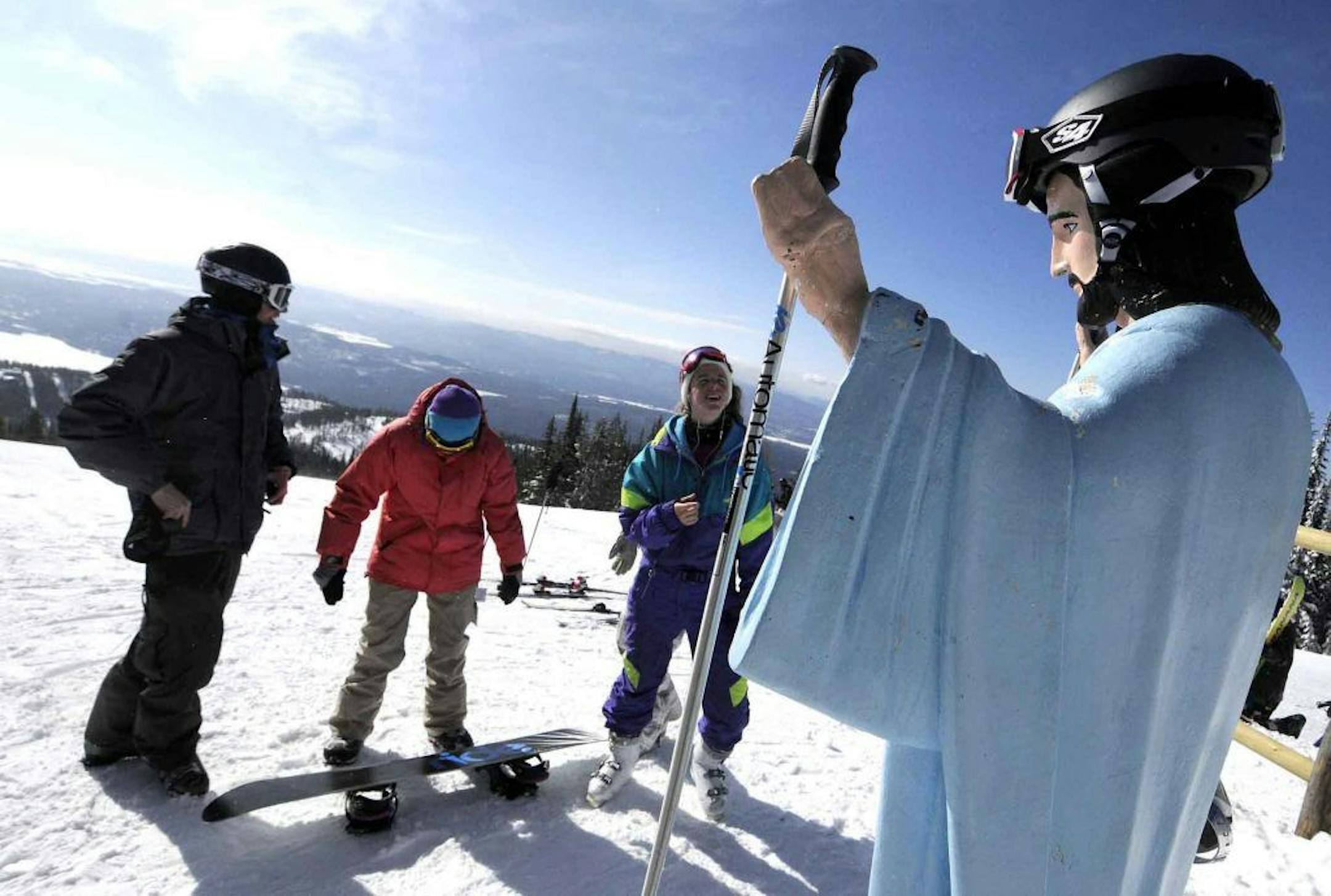 FILE - In this Feb. 20, 2011 file photo, freshmen at the University of Montana, Jake Coburn, Stephanie Ralls and Claire Dal Nogare, from left, visit a statue of Jesus Christ at Whitefish Mountain Resort Whitefish, Mont. A Montana judge says a 6-foot-tall statue of Jesus that was placed on federal land on Big Mountain near Whitefish nearly 60 years ago can remain.