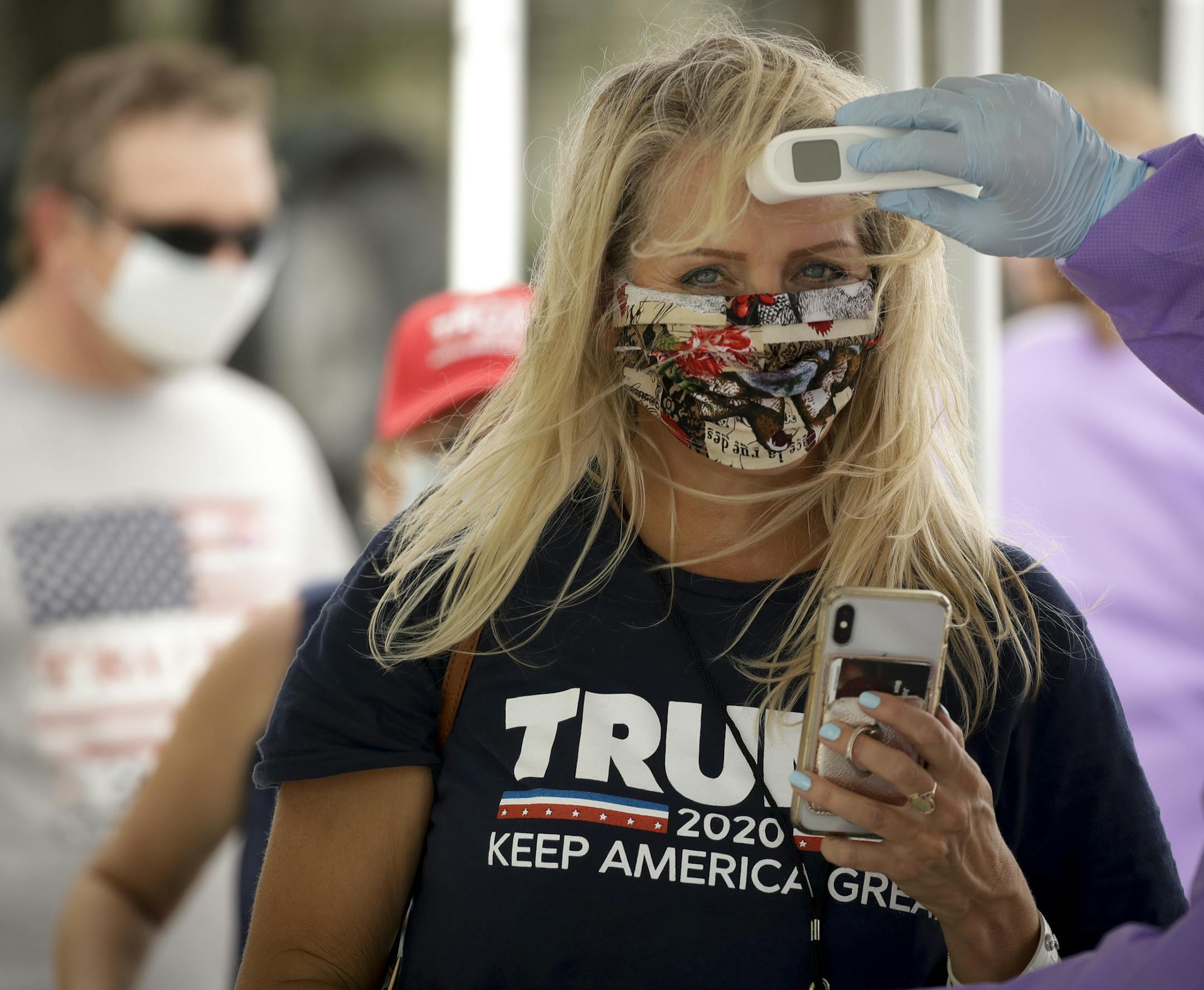 A supporter gets her temperature checked prior to attending a campaign rally for President Trump at the BOK Center in Tulsa, Okla., Saturday, June 20, 2020. (AP Photo/Charlie Riedel)