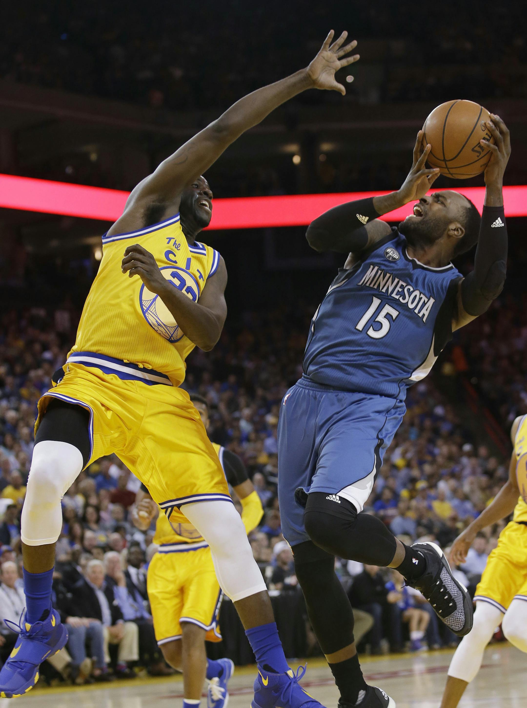 Minnesota Timberwolves' Shabazz Muhammad (15) shoots over Golden State Warriors' Draymond Green (23) during the first half of an NBA basketball game Tuesday, April 5, 2016, in Oakland, Calif. (AP Photo/Marcio Jose Sanchez)