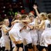 Roseau players begin the celebration near the end their 75-64 victory over Sauk Centre during the girls' basketball state tournament, Class 2A champio
