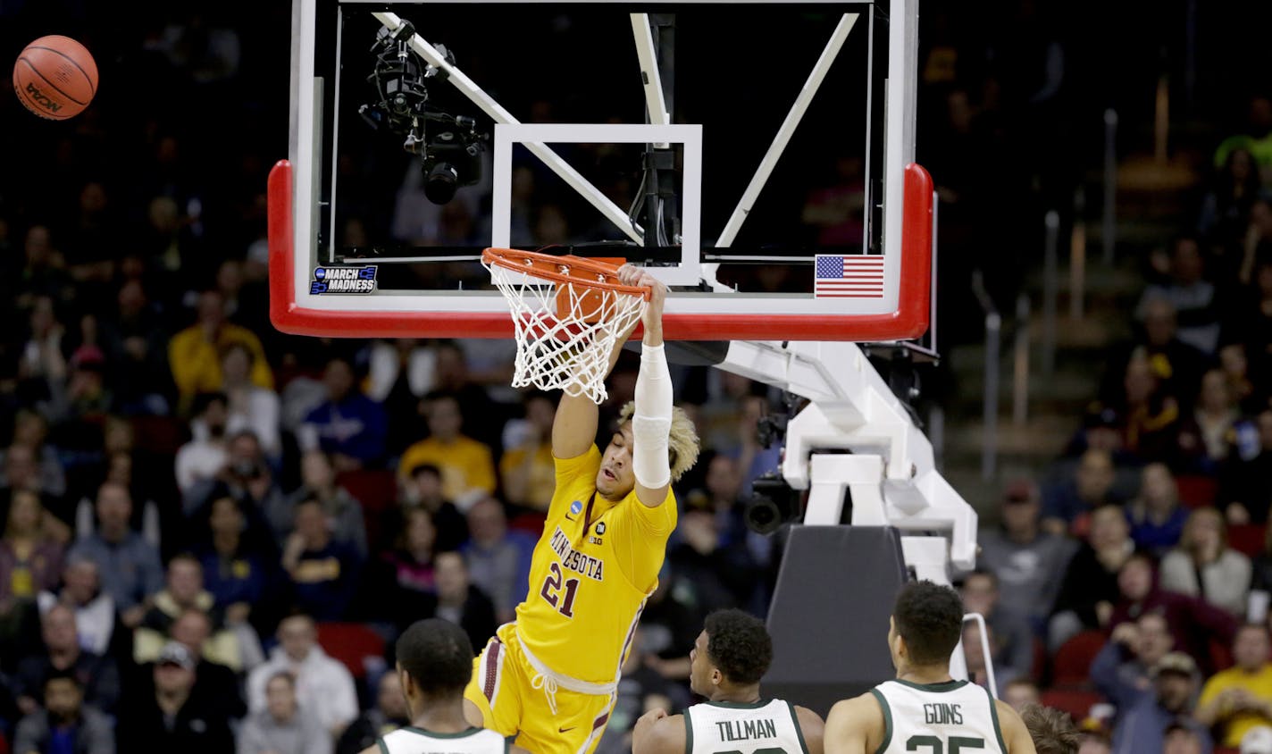 Minnesota's Jarvis Omersa (21) misses a dunk as Michigan State's Xavier Tillman (23) and Kenny Goins (25) watch, during the second half of a second round men's college basketball game in the NCAA Tournament, in Des Moines, Iowa, Saturday, March 23, 2019. (AP Photo/Nati Harnik)