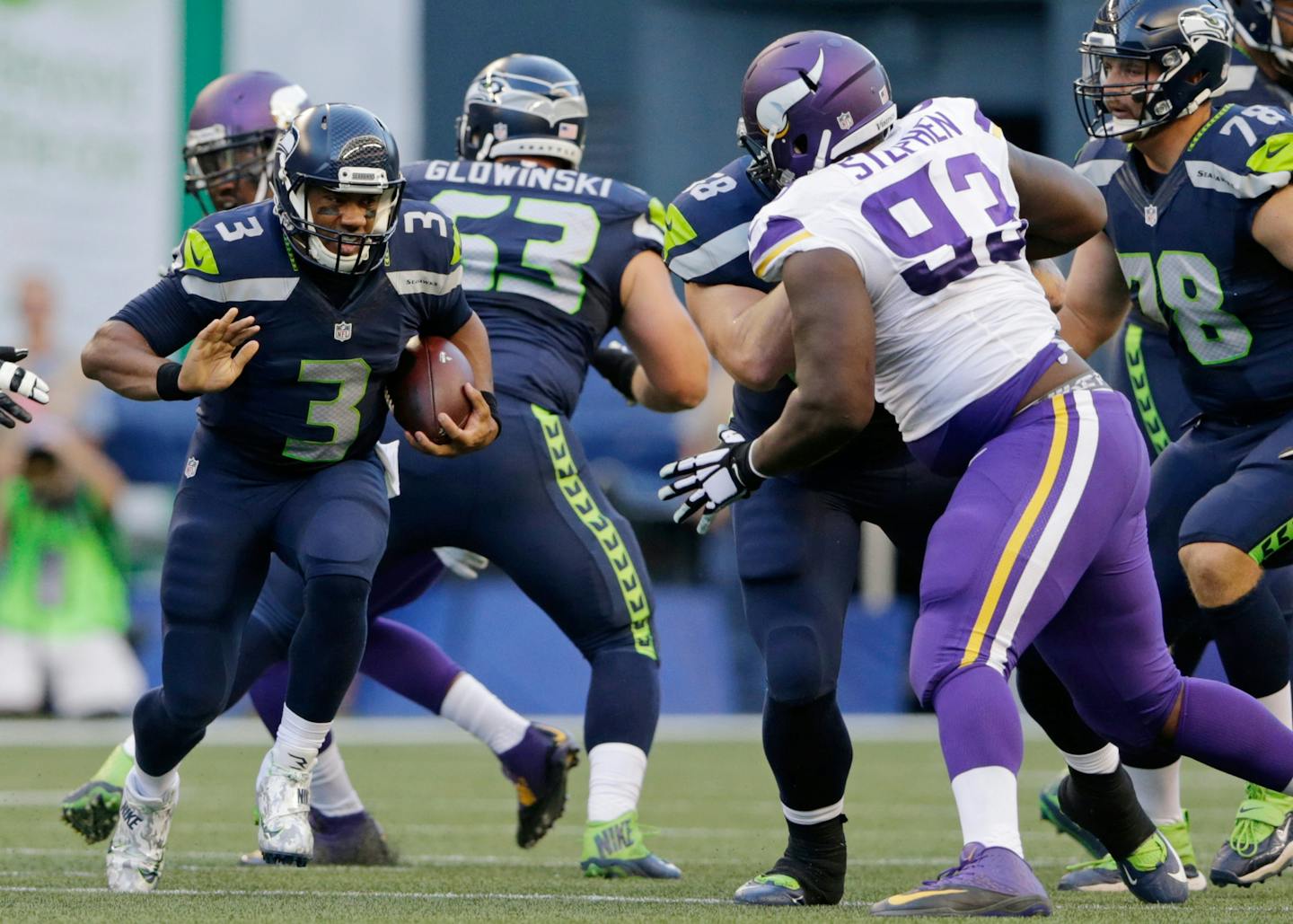 Seattle Seahawks quarterback Russell Wilson, left, runs the ball as Minnesota Vikings defensive tackle Shamar Stephen (93) closes in during the first half of a preseason NFL football game Thursday, Aug. 18, 2016, in Seattle. (AP Photo/John Froschauer)