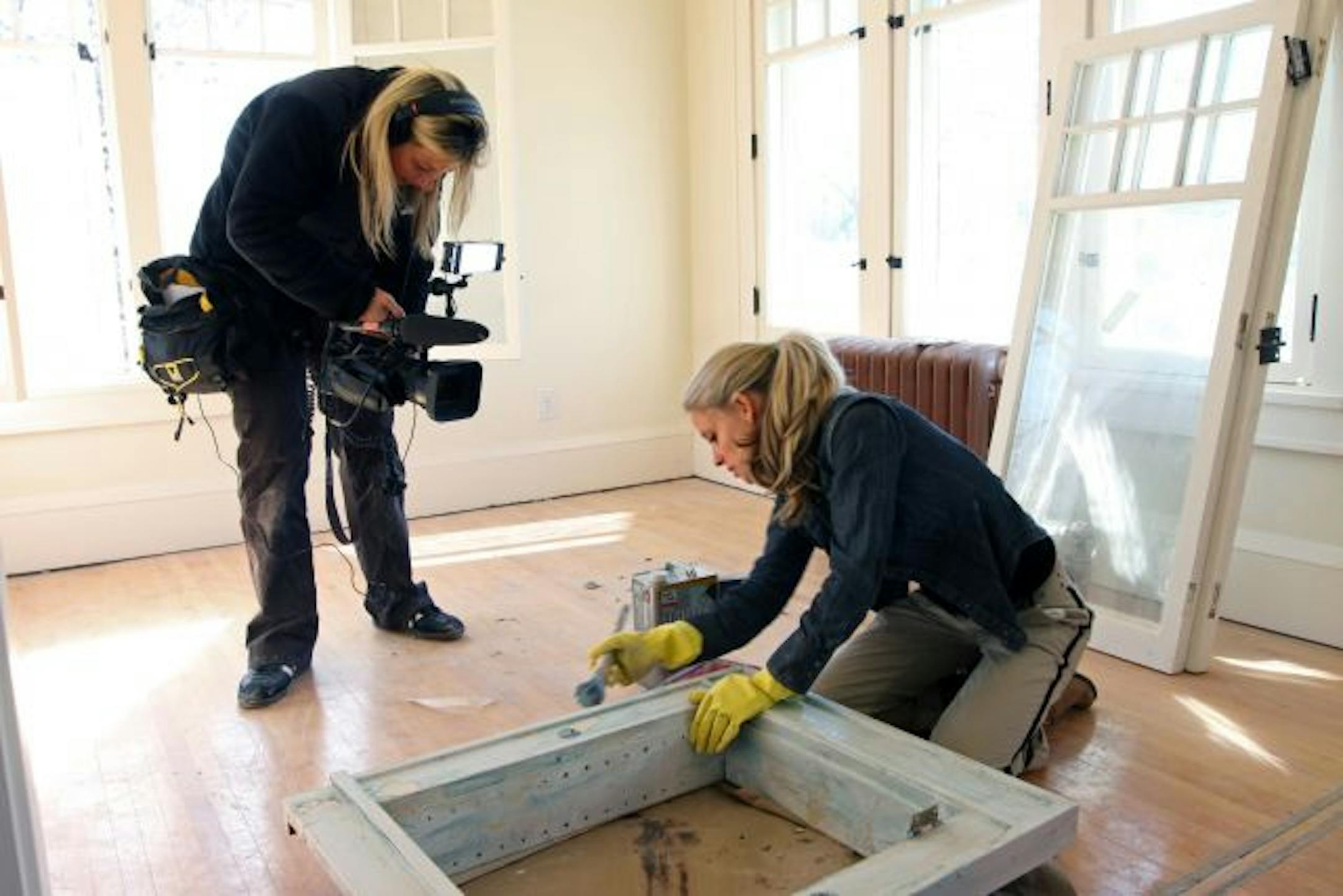 Production crew photographer Christina Hilbid taped Nicole Curtis as they filmed a segment on stripping the paint off a medicine cabinet in a south Minneapolis house.