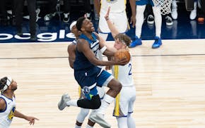 Timberwolves guard Anthony Edwards (5) attempts a layup while being guarded by Golden State Warriors forward Jimmy Butler III (10) and Warriors guard