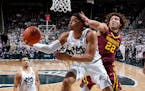 Michigan State's Miles Bridges, center, puts up a reverse layup against Minnesota's Reggie Lynch (22) as Michigan State's Kenny Goins, left, watches d