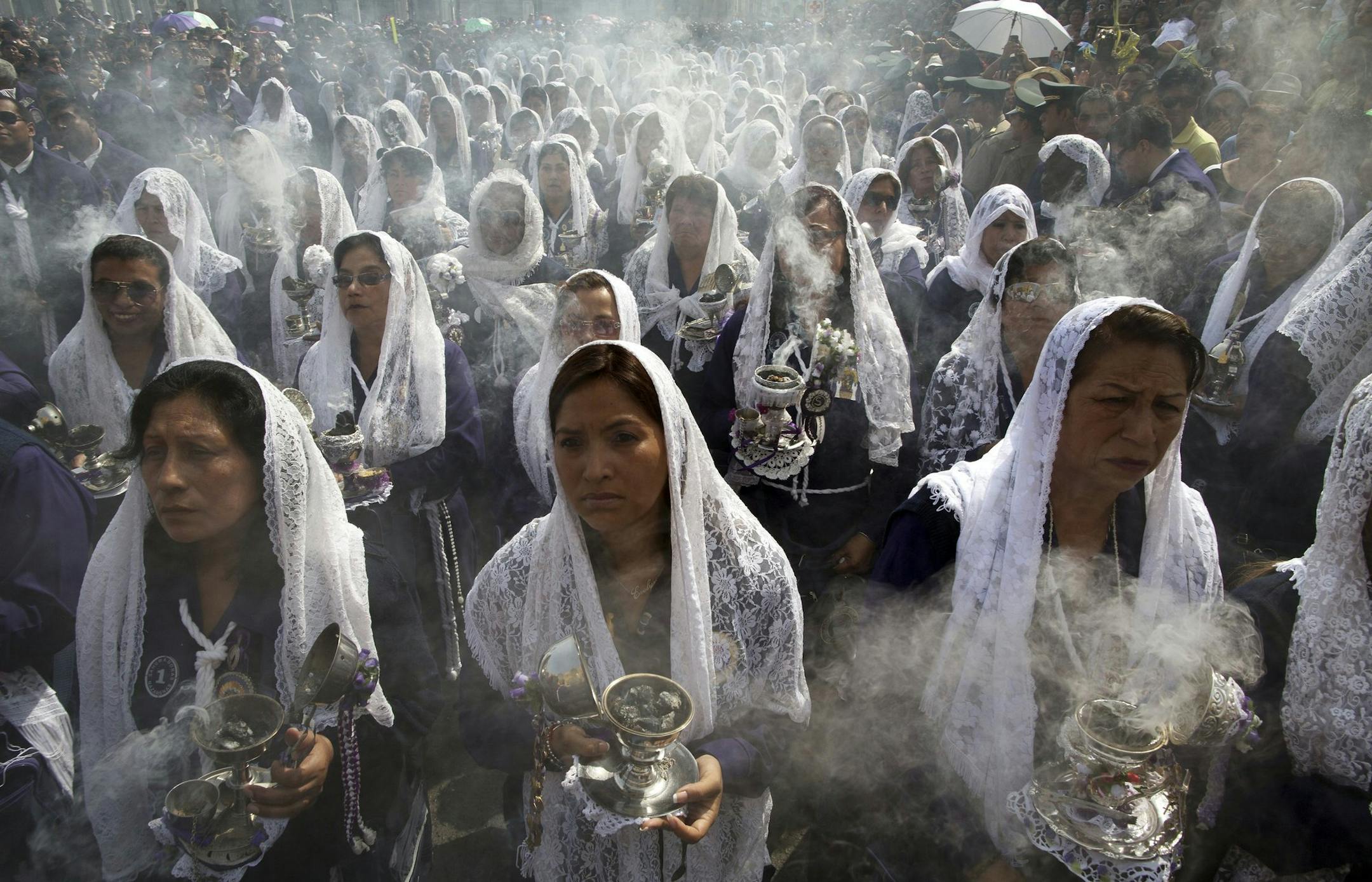 Women burn incense as they take part in a Good Friday procession honoring "The Lord of Miracles", the patron saint of Lima, Peru, Friday, April 3, 2015. Devout Christians in Peru commemorate the death of Jesus Christ on Good Friday with processions and reenactments of the Stations of the Cross, or Jesus Christ's final procession to his crucifixion. (AP Photo/Rodrigo Abd)