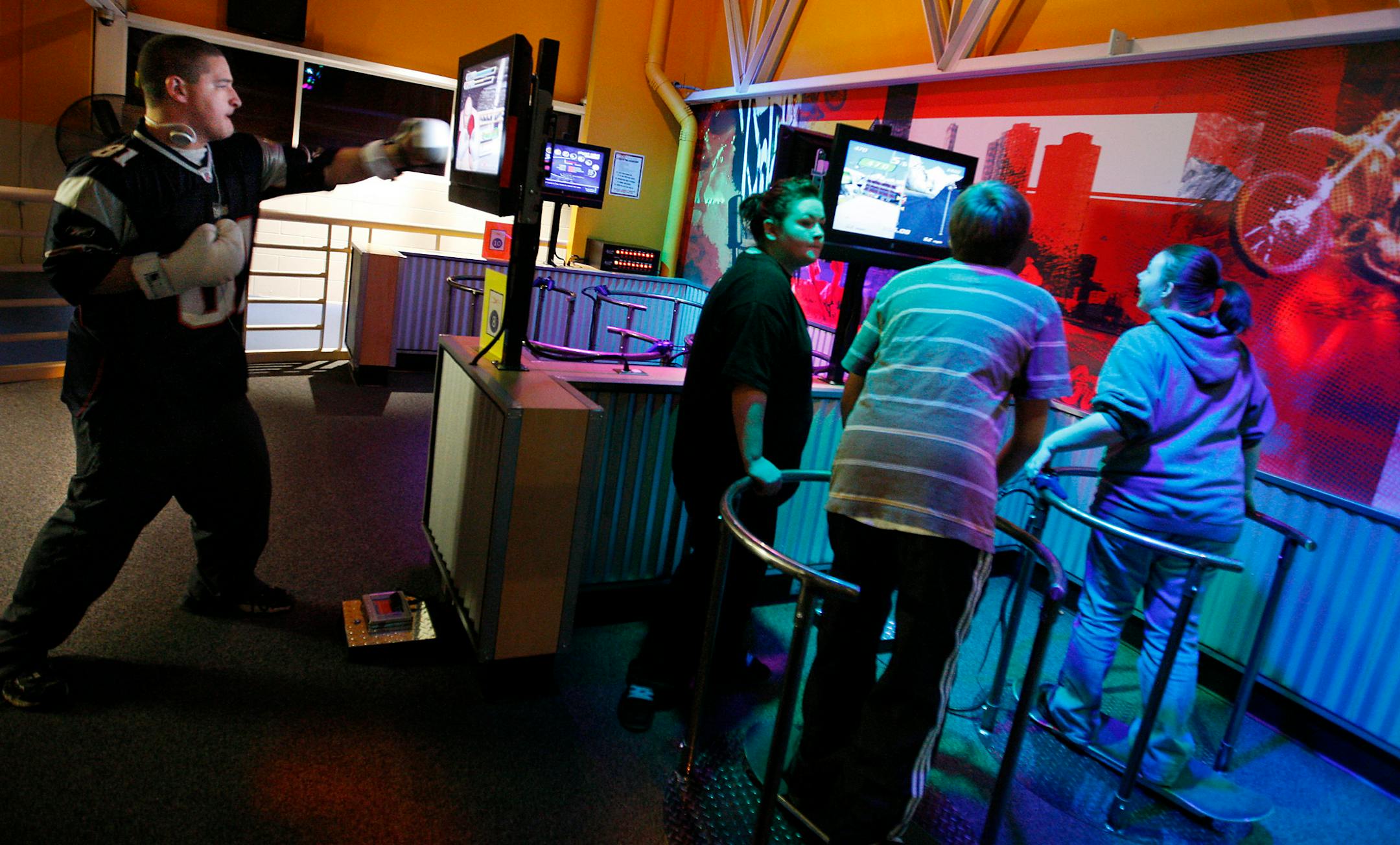 At the XRKade in the North St. Paul Community Center, Dan Humbert, left, was boxing away and knocking his virtual opponents down. Humbert, 15, plays football for Roseville Area High School and considers the exergames legitimate fitness exercises.