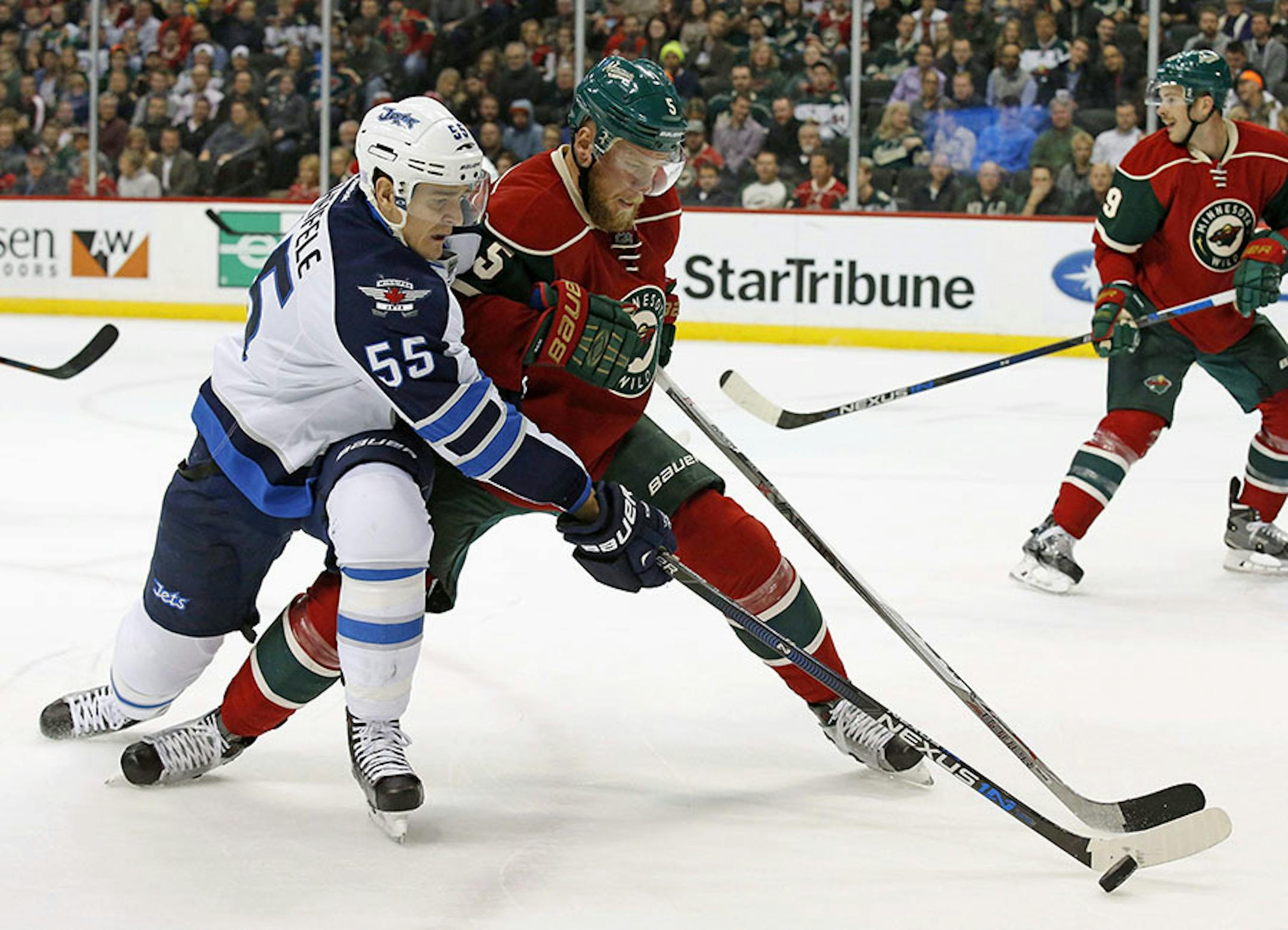 Winnipeg Jets center Mark Scheifele (55) and Minnesota Wild defenseman Christian Folin, right, of Sweden, battle for the puck during the second period of an NHL hockey game in St. Paul, Minn., Tuesday, Nov. 10, 2015. (AP Photo/Ann Heisenfelt)