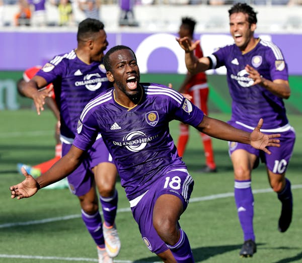 Orlando City 's Kevin Molino (18) celebrates after scoring a goal against the New England Revolution as teammates Julio Baptista, left, and Kaka (10) 