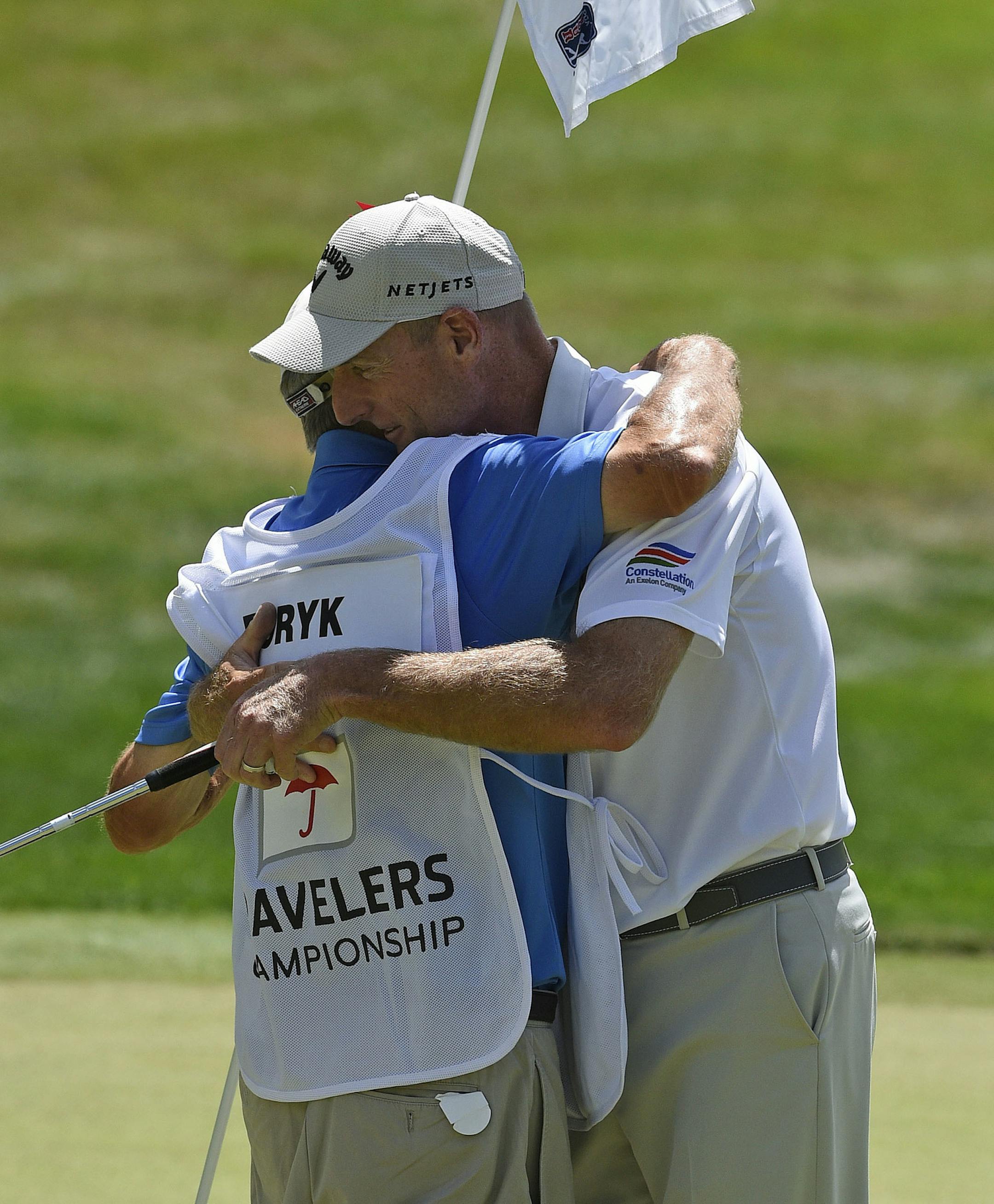 Jim Furyk celebrates with his caddy Mike, Fluff, Cowan after shooting a PGA record 58 during the final round of the Travelers Championship golf tournament in Cromwell, Conn., Sunday, Aug. 7, 2016. (AP Photo/Fred Beckham)