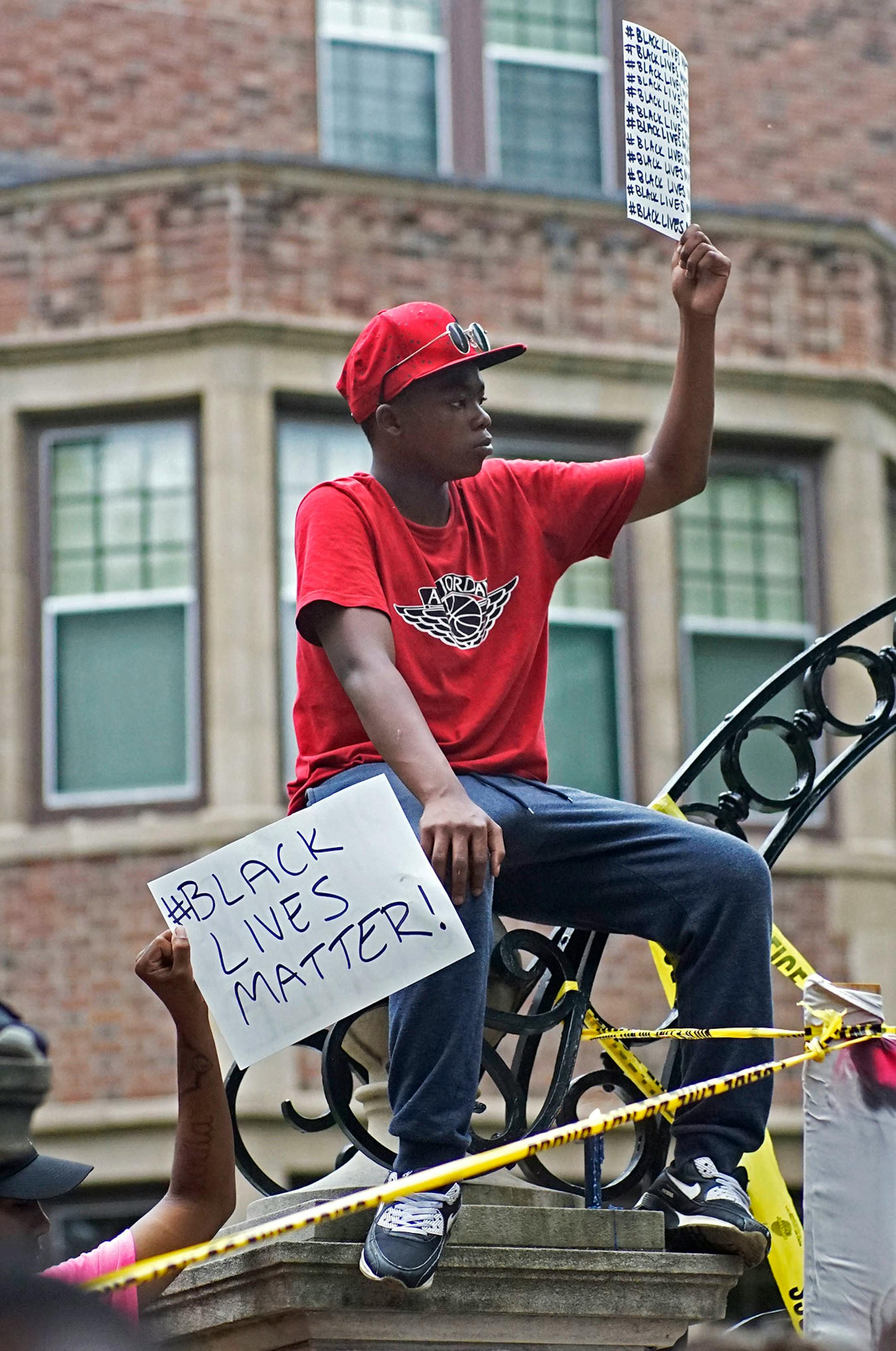 A young protester sat on top of the entrance gate.
