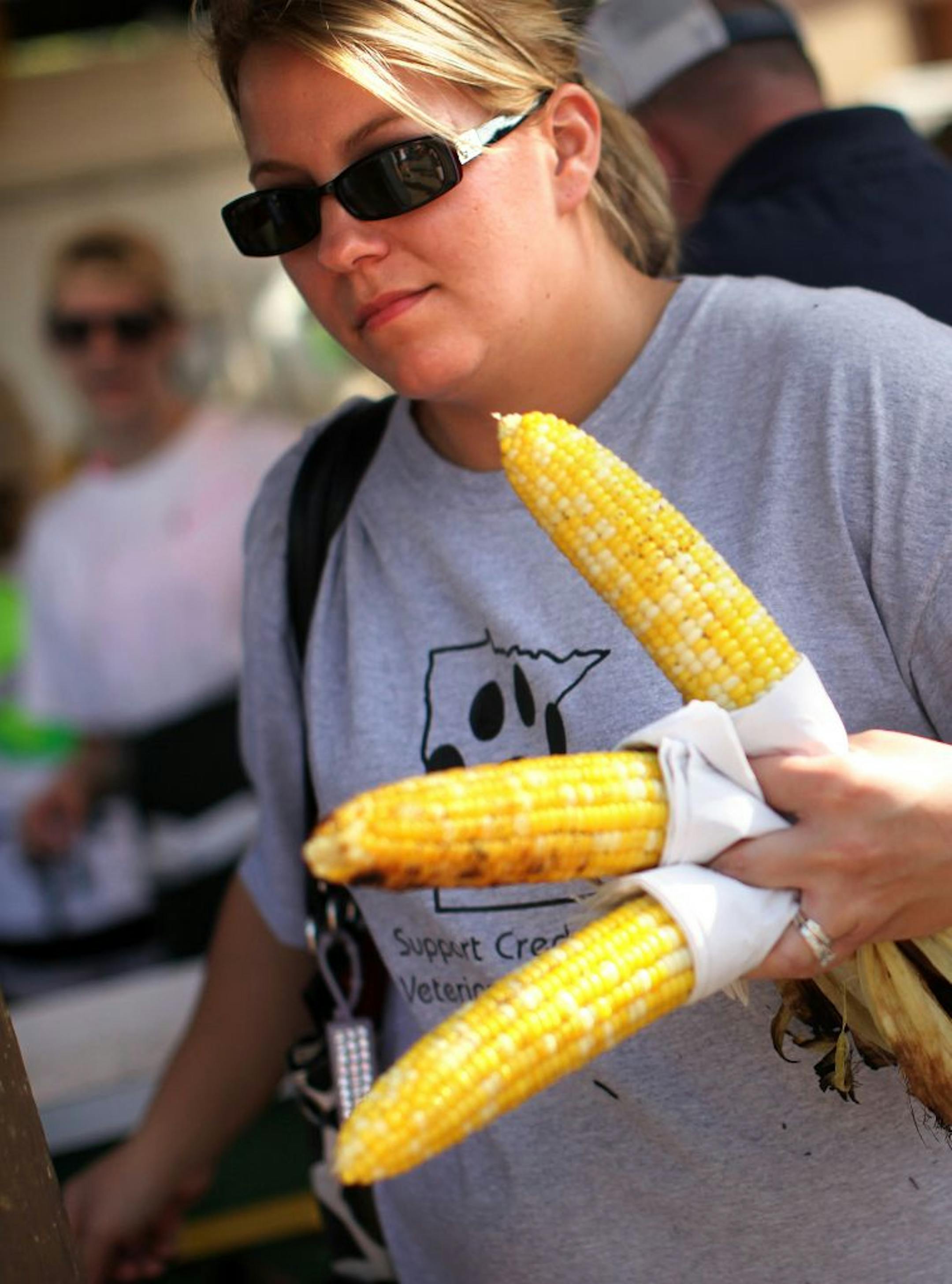 Audrey Colligan, of Stewartville, Minn., carried a handful of roasted corn for her family on Monday, August 29, 2011, at the Minnesota State Fair in Falcon Heights, Minn.