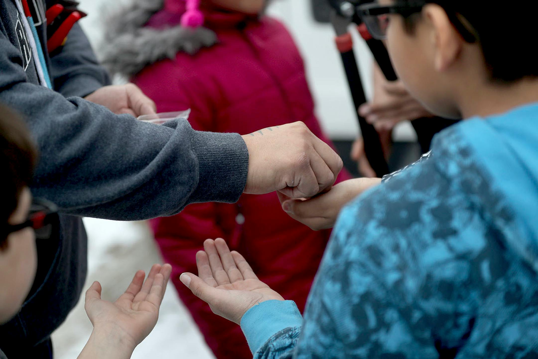 Teacher Mat Pendleton, who holds multiple positions with the Lower Sioux Community, hands out traditional tobacco after explaining to young community members how they leave a tobacco offering near the trees before they begin to harvest any.