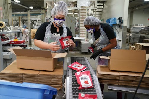 Naomi Hoffeeck and Denice Roberts boxed up packages of Wiley Wallaby Licorice from a conveyor at Kenny's Candy Wednesday morning. ] ANTHONY SOUFFLE • anthony.souffle@startribune.com Ken Nelson, founder of the Kenny's Candy Company, gave tour Wednesday, Oct. 7, 2020 of the town of Perham, Minn. where they make candy, potato chips and dog food, and their main problem is finding a place to put all the people who have jobs there.