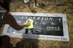Sandy Cikotte Anderson cleans off her son Robert’s grave marker at Forest Hill Cemetery on Thursday, May 11, 2023, in Anoka. A second autopsy says t