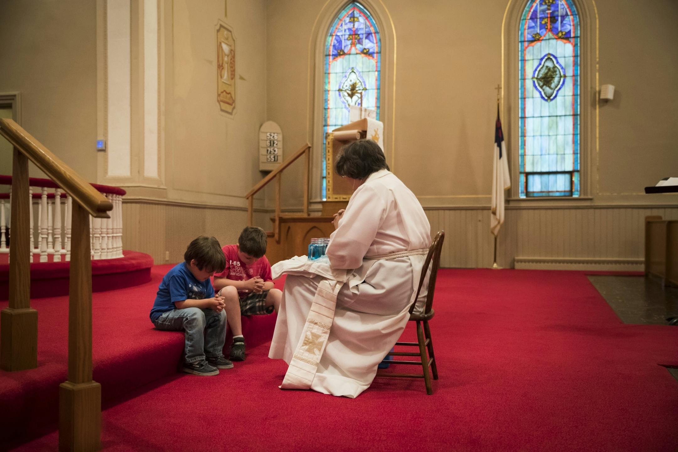 Rev. Maureen Hagen prayed with Andrew Weigman, 4, and his brother Nick Weigman, 6. after giving a little children's message at the front of the church during Sunday service at Vasa Lutheran Church in Vasa, Minn., on Sunday, June 11, 2017.