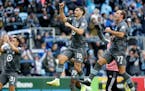 Minnesota United players, including Hassani Dotson (31), Michael Boxall (15) and Chase Gasper (77), salute the crowd after defeating Sporting Kansas C