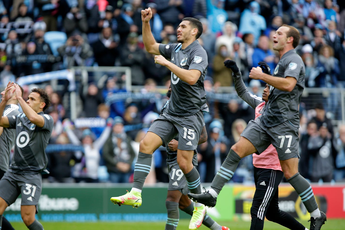 Minnesota United players, including Hassani Dotson (31), Michael Boxall (15) and Chase Gasper (77), salute the crowd after defeating Sporting Kansas City in an MLS soccer match, Sunday, Oct. 31, 2021, in St. Paul, Minn. (AP Photo/Andy Clayton-King)