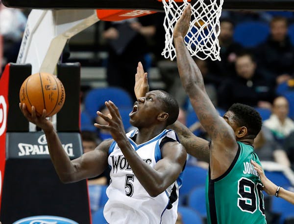 Minnesota Timberwolves' Gorgui Dieng, left, of Senegal, eyes the basket as Boston Celtics' Amir Johnson defends during the first quarter of an NBA bas
