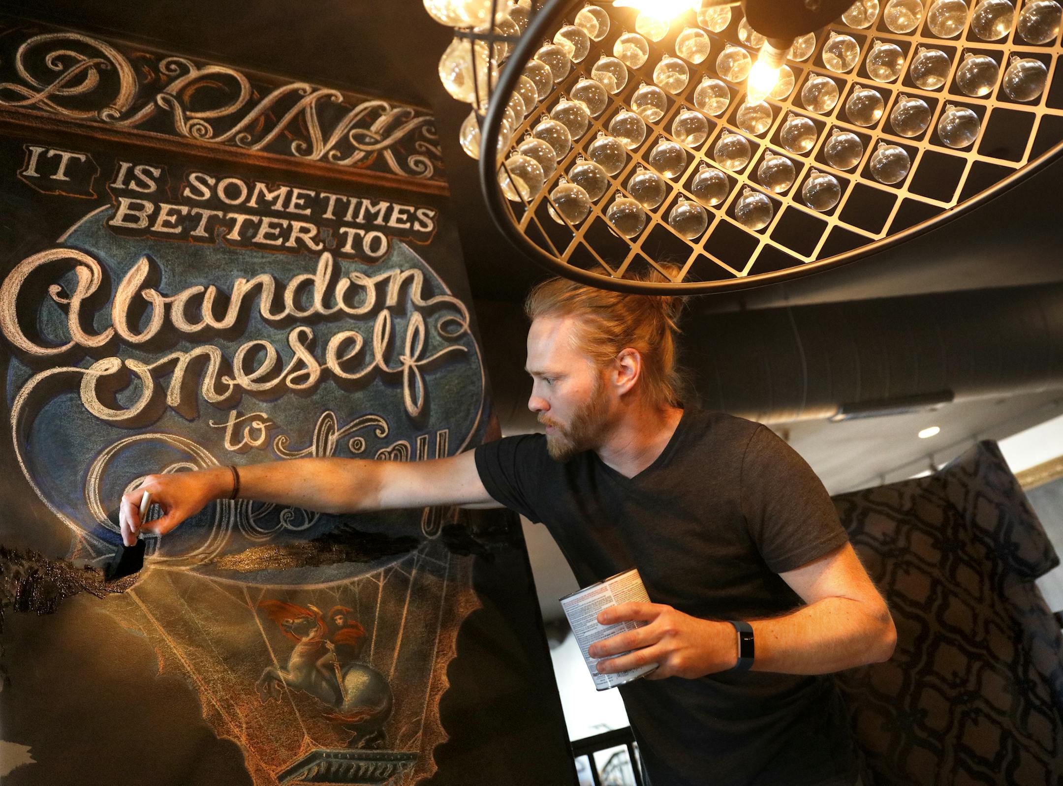 Multidisciplinary artist Adam Dennis worked on his murals at Coup d&#x2019;Etat restaurant in Uptown.