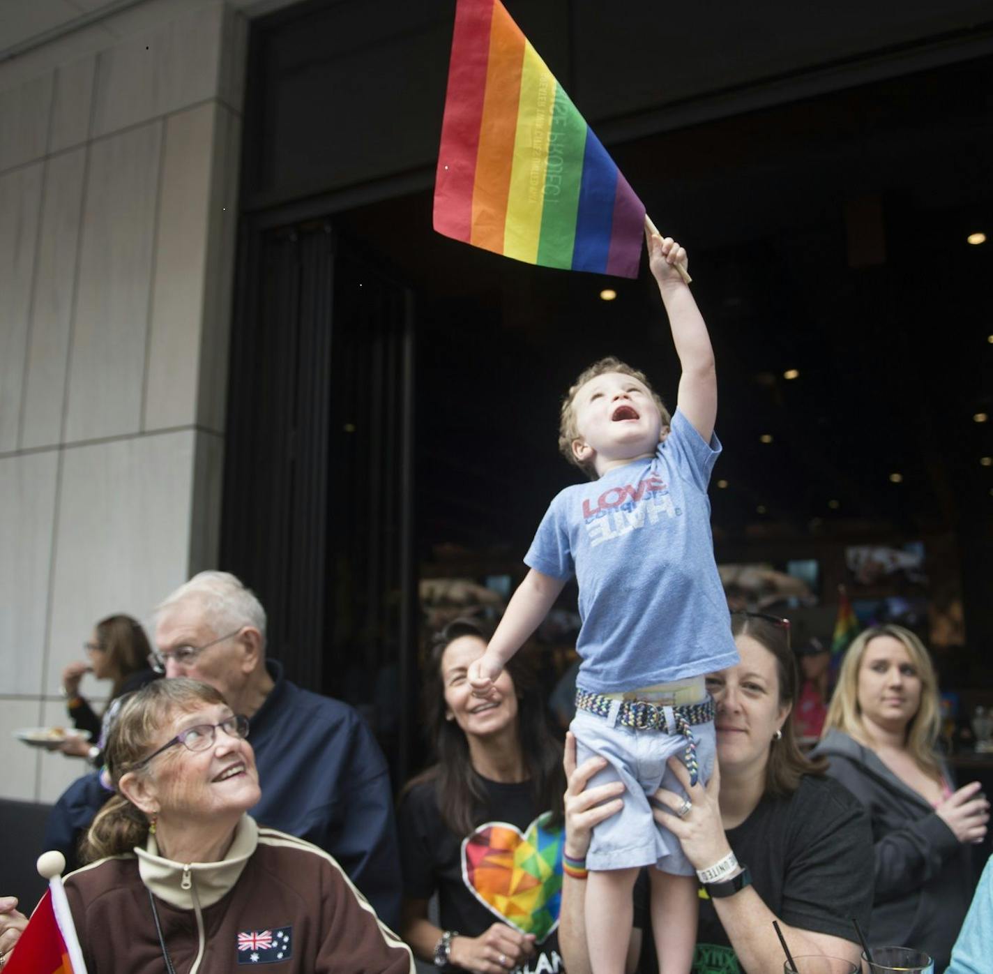 In this 2017 photo, families celebrate at the annual Twin Cities Pride parade-watching part. After a year without celebrations, the community is looking forward to the return of a scaled-down Pride celebration in Loring Park in July.