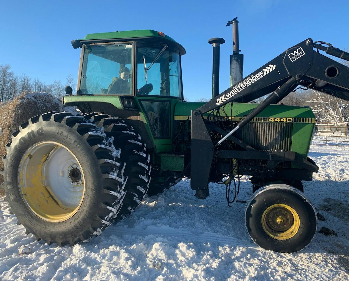 Track Folland, son of Kris Folland, feeds cattle at the family's farm near Halma using a 1979 John Deere 4440.