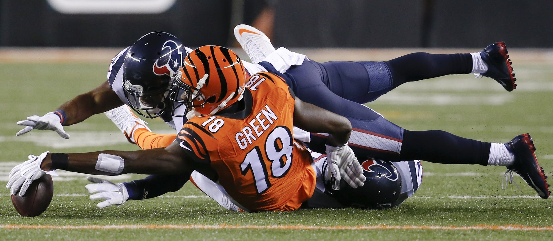 Houston Texans strong safety Quintin Demps (27) goes over Cincinnati Bengals wide receiver A.J. Green (18) for a loose ball in the second half of an NFL football game in Cincinnati, Monday, Nov. 16, 2015. The Texans recovered the fumble. The Texans defeated the Bengals 10-6 (AP Photo/Frank Victores)