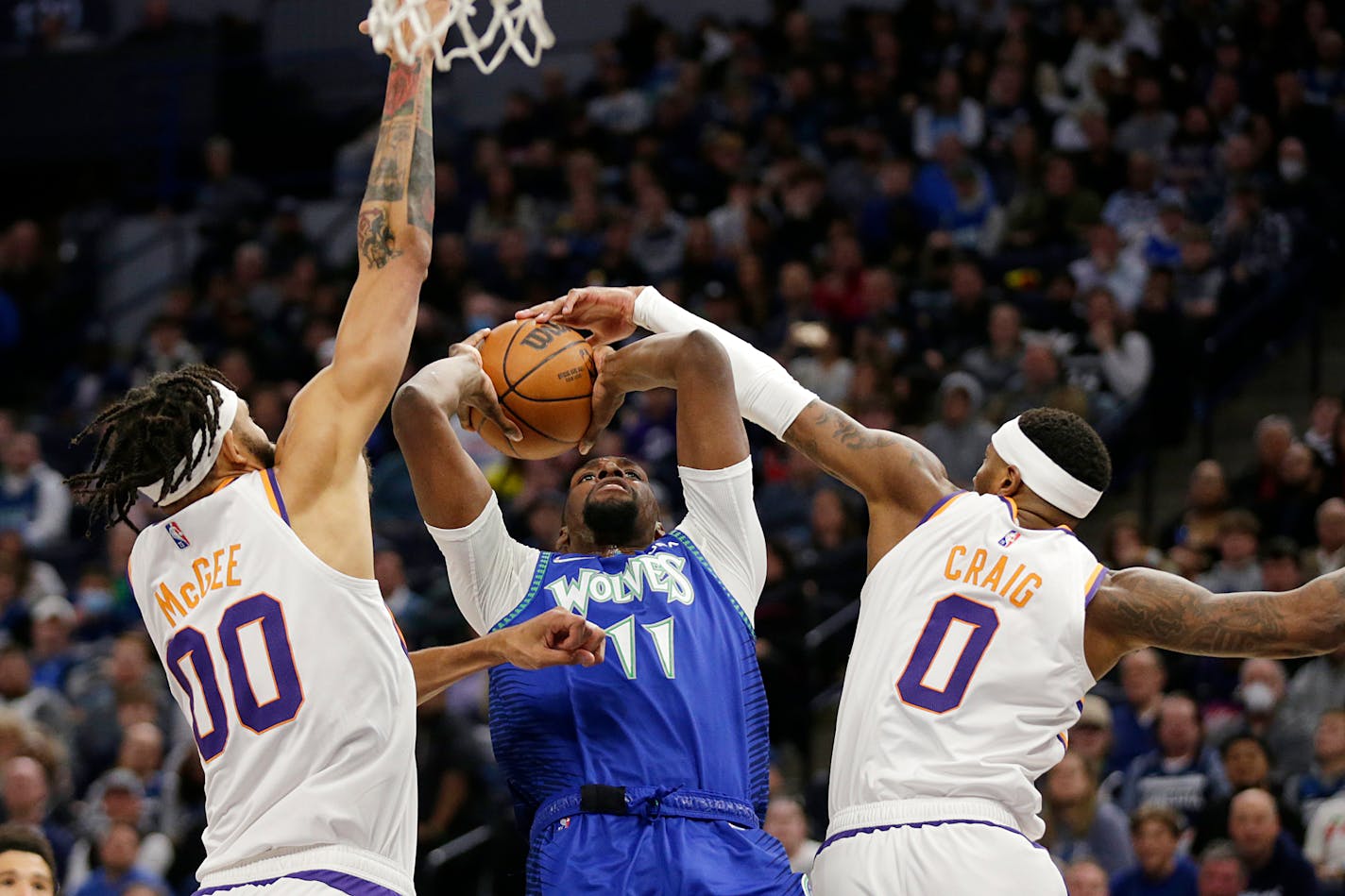 Minnesota Timberwolves center Naz Reid (11) has his shot blocked by Phoenix Suns forward Torrey Craig (0) with defensive help from Suns center JaVale McGee (00) during the second half of an NBA basketball game Wednesday, March 23, 2022, in Minneapolis. (AP Photo/Andy Clayton-King)