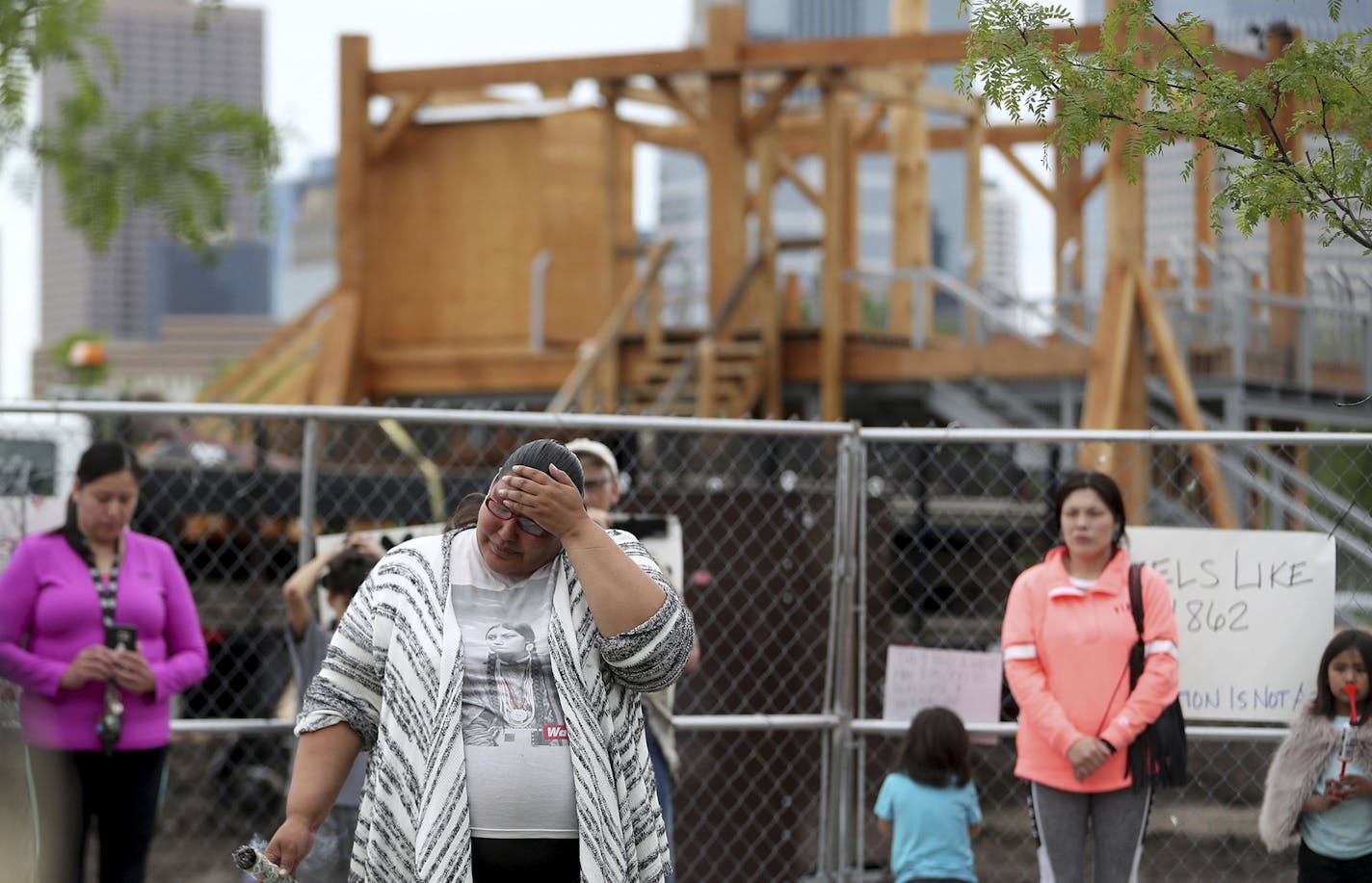 Crystal Norcross, a Sisseton Wahpeton Dakota from Sisseton S.D., speaks to a crowd gathered near the Walker Sculpture Garden Saturday, May 27, 2017, in Minneapolis. The Walker Art Center in Minneapolis said Saturday it will remove "Scaffold," a two-story sculpture from 2012 by Los Angeles artist Sam Duranta, because of protests from Native Americans who say it brought back painful memories of the mass hanging of 38 Dakota men in 1862. (David Joles/Star Tribune via AP) ORG XMIT: MIN20170530104244