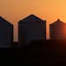 Corn silos are silhouetted by a setting sun Thursday, July 21, 2016, in Pleasant Plains, Ill. The Midwest's first dangerous bout of summer heat and hu