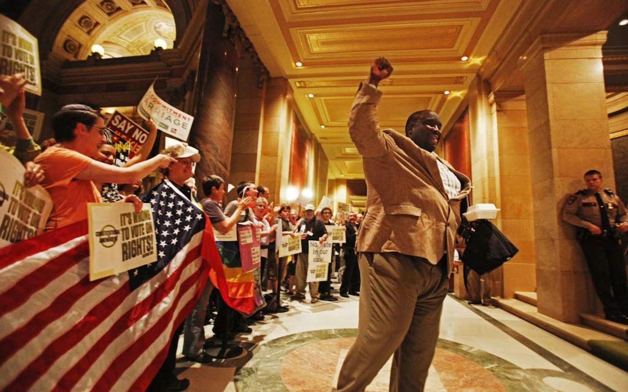 Rep. Jeff Hayden, DFL-Minneapolis, pumps his fist in support of protesters against a constitutional amendment against gay marriage outside the House chambers during Friday evening's session.