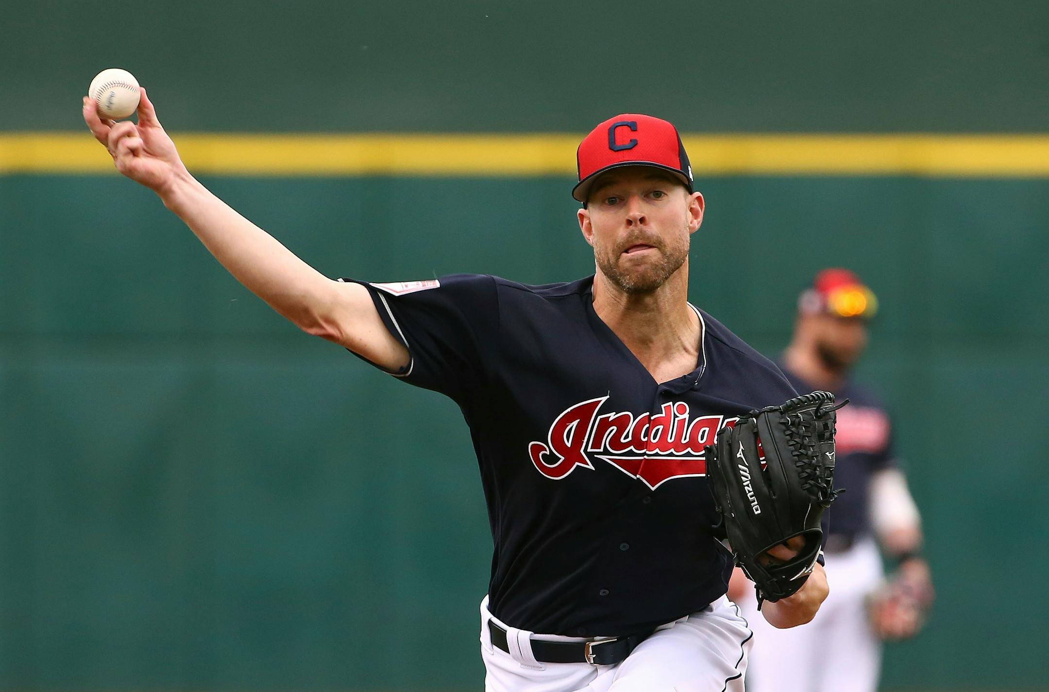 FILE - In this March 11, 2019, file photo, Cleveland Indians starting pitcher Corey Kluber throws a warm up pitch before a spring training baseball game against the Cincinnati Reds in Goodyear, Ariz. The Indians have their sights set on their first World Series title since 1948, but to get it they'll have to replenish some power lost during the offseason and get by league powers Houston, New York and Boston. (AP Photo/Ross D. Franklin, File)