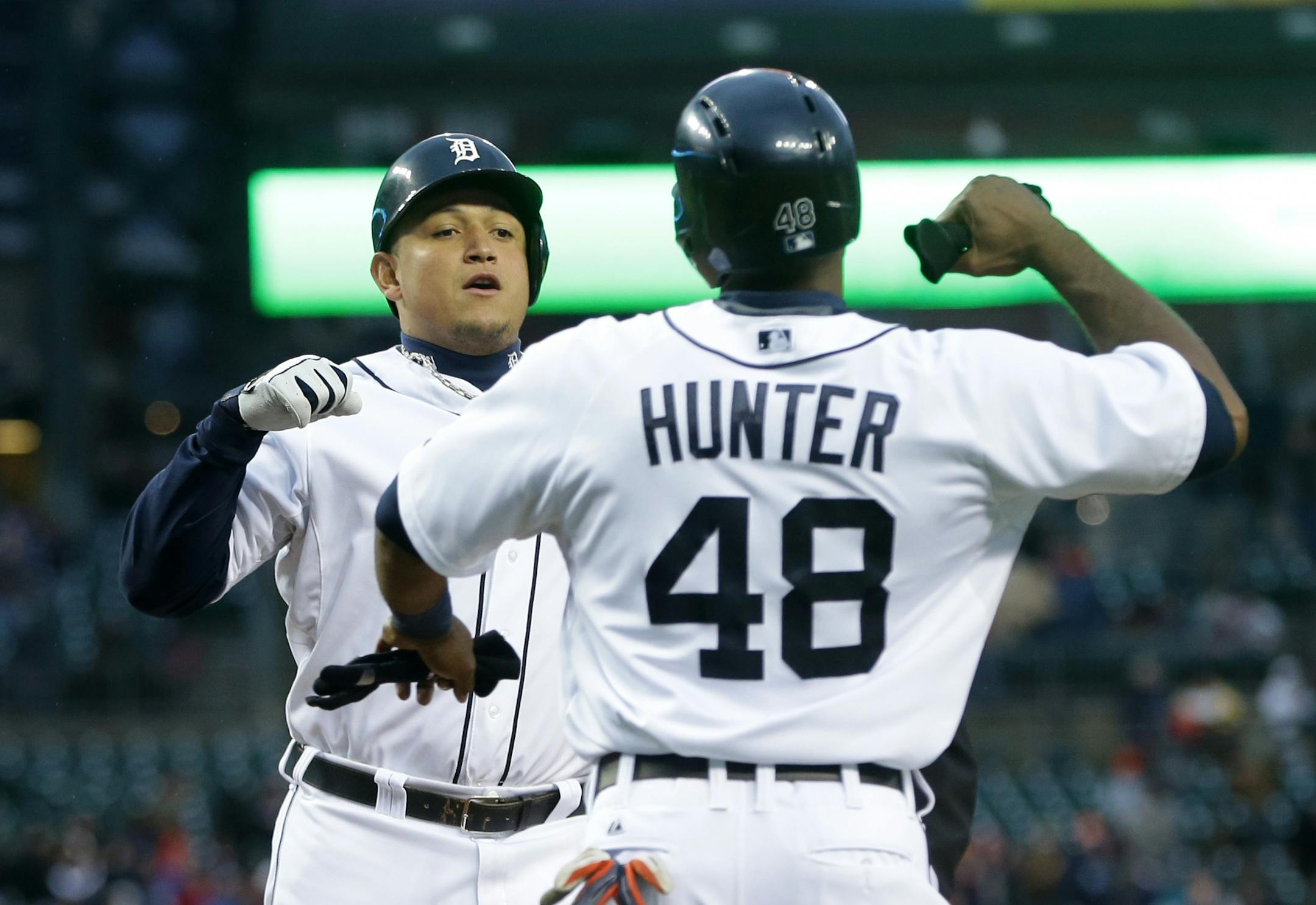 Detroit Tigers' Miguel Cabrera is congratulated by teammate Torii Hunter after hitting a two-run home run during the first inning of a baseball game against the Minnesota Twins in Detroit