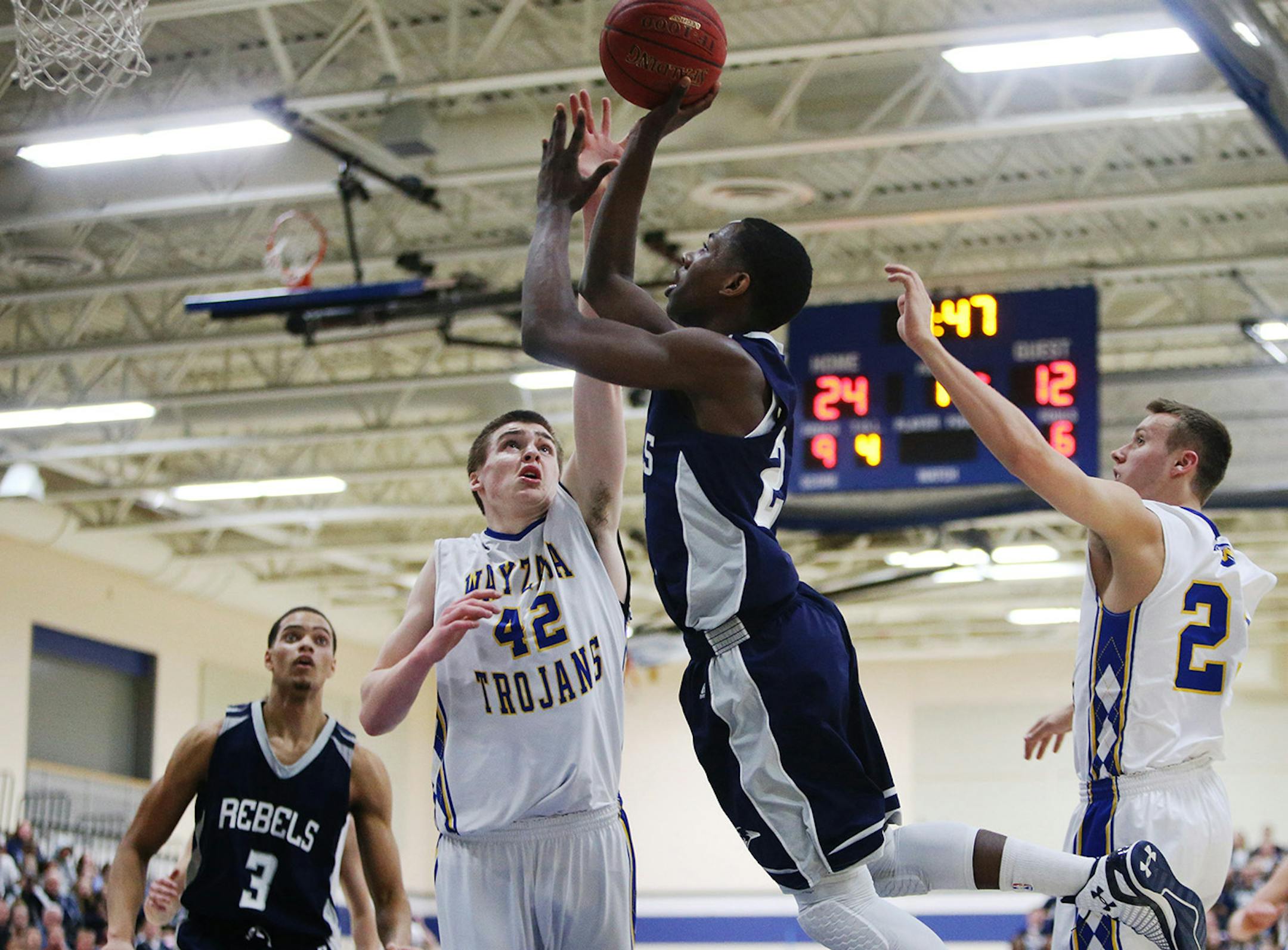 Champlin Park High's McKinley Wright drives to the basket against Wayzata High's Troy Louwagie (42) during the first half of the Class 4A, Section 5 boys' basketball section final at Roger High School Friday, March 6, 2015, in Rogers, MN.