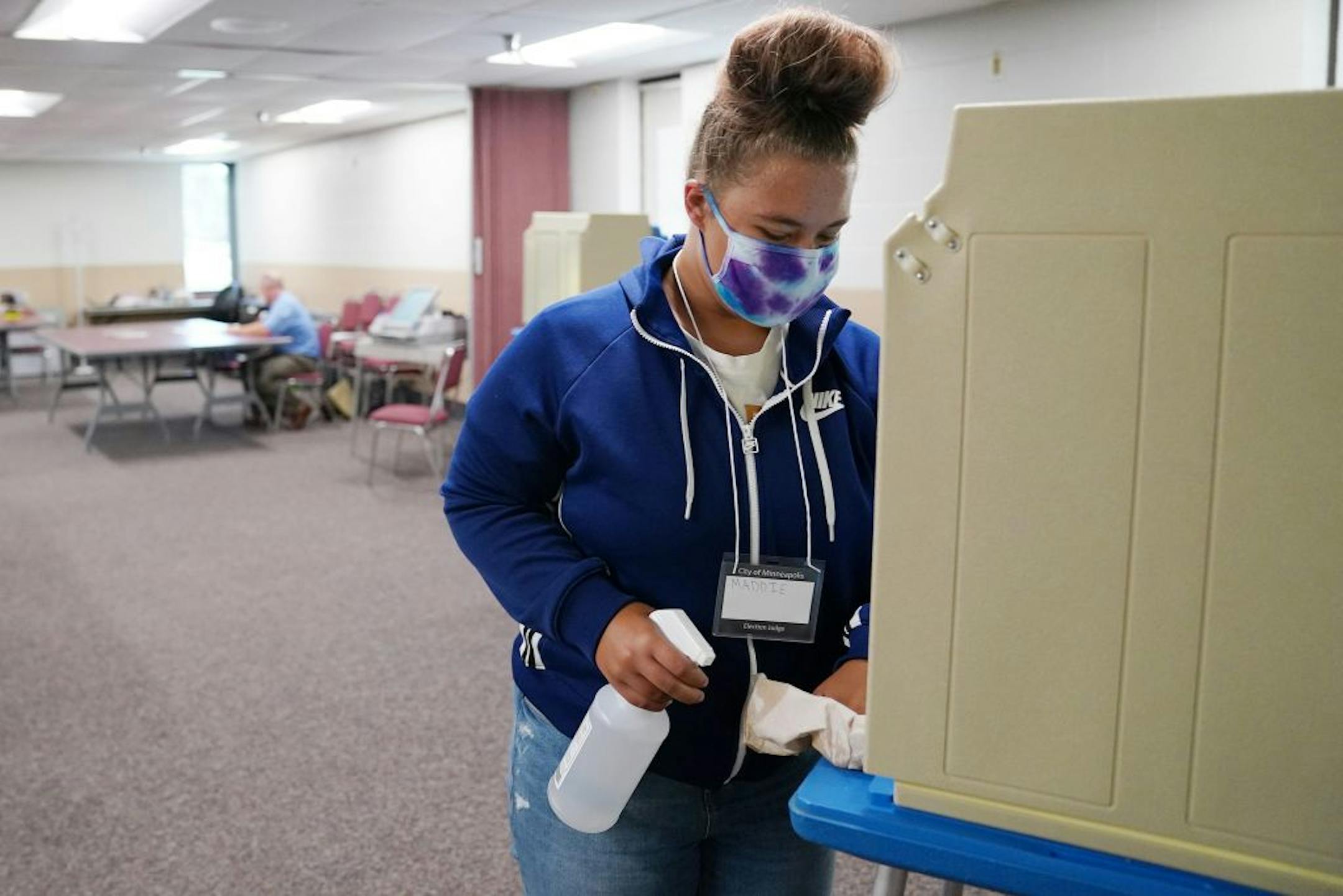 Maddie Nolen used disinfectant to sanitize the voting booths at the Minnesota Army National Guard N.E. Minneapolis Training and Community Center Tuesday in Minneapolis.