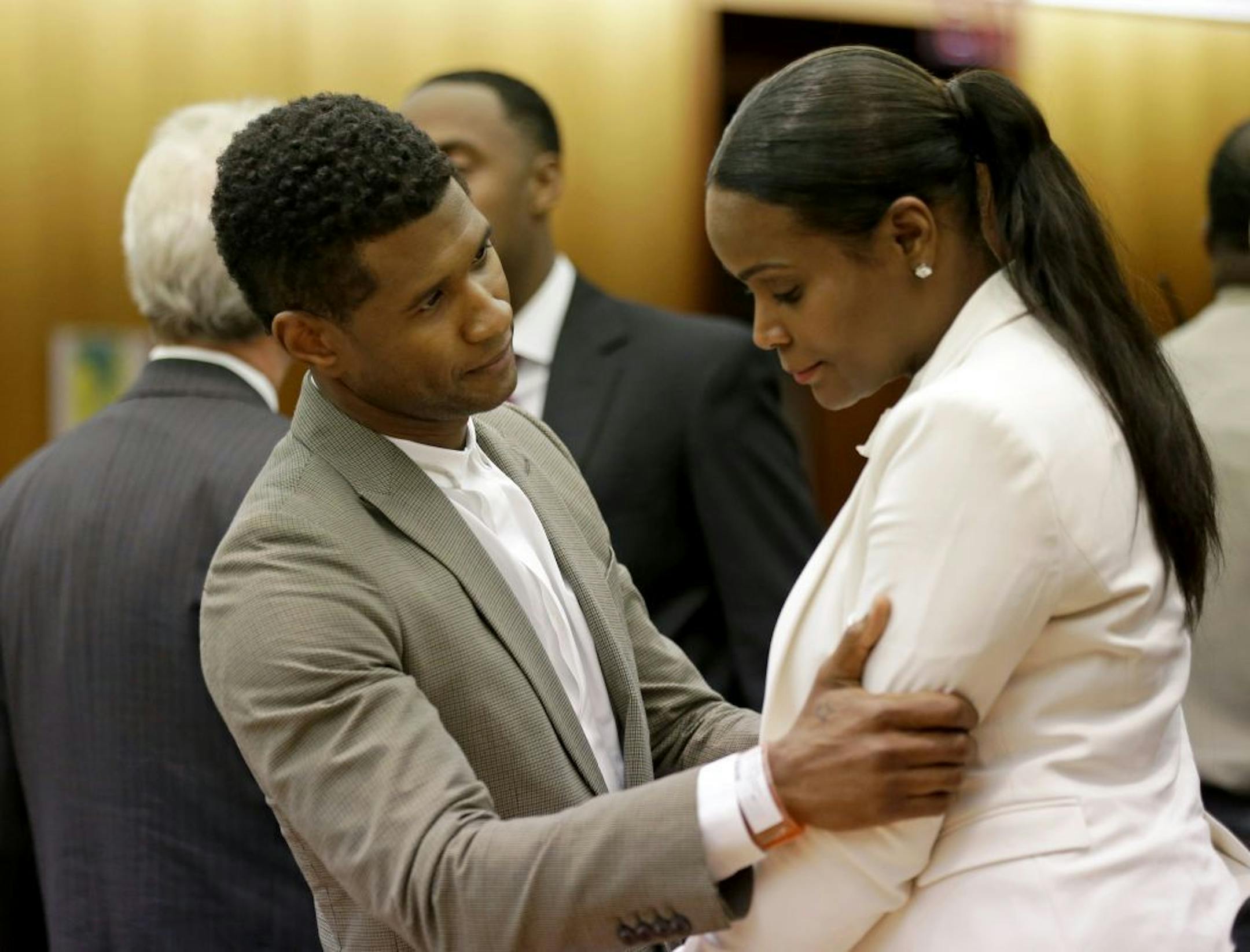 R&B singer Usher, left, embraces ex-wife Tameka Foster Raymond, after a judge dismissed an emergency request by Raymond seeking temporary custody of their two children, Friday, Aug. 9, 2013, in Atlanta. Raymond had requested the hearing earlier this week after their 5-year-old son got caught in a pool drain while in the care of the Grammy winner's aunt. After a hearing in which both Usher and Raymond took the stand, Fulton County Superior Court Judge John Goger dismissed her request for temporar