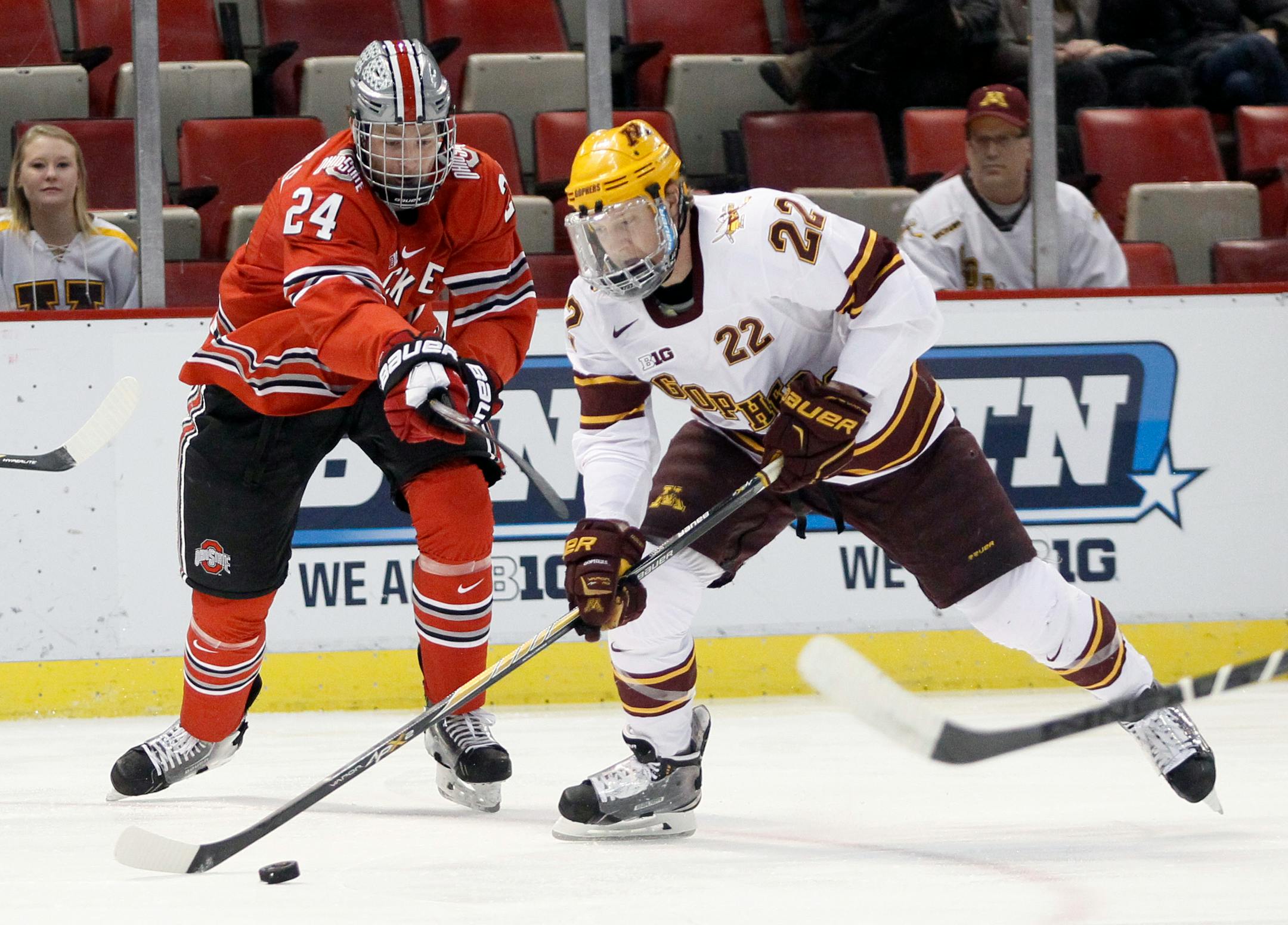 Minnesota's Travis Boyd (22) is pursued by Ohio State's Craig Dalrymple (24) while driving towards the goal during the first period of an NCAA college hockey game in the Big Ten Conference tournament Friday, March 20, 2015, in Detroit. (AP Photo/Duane Burleson)