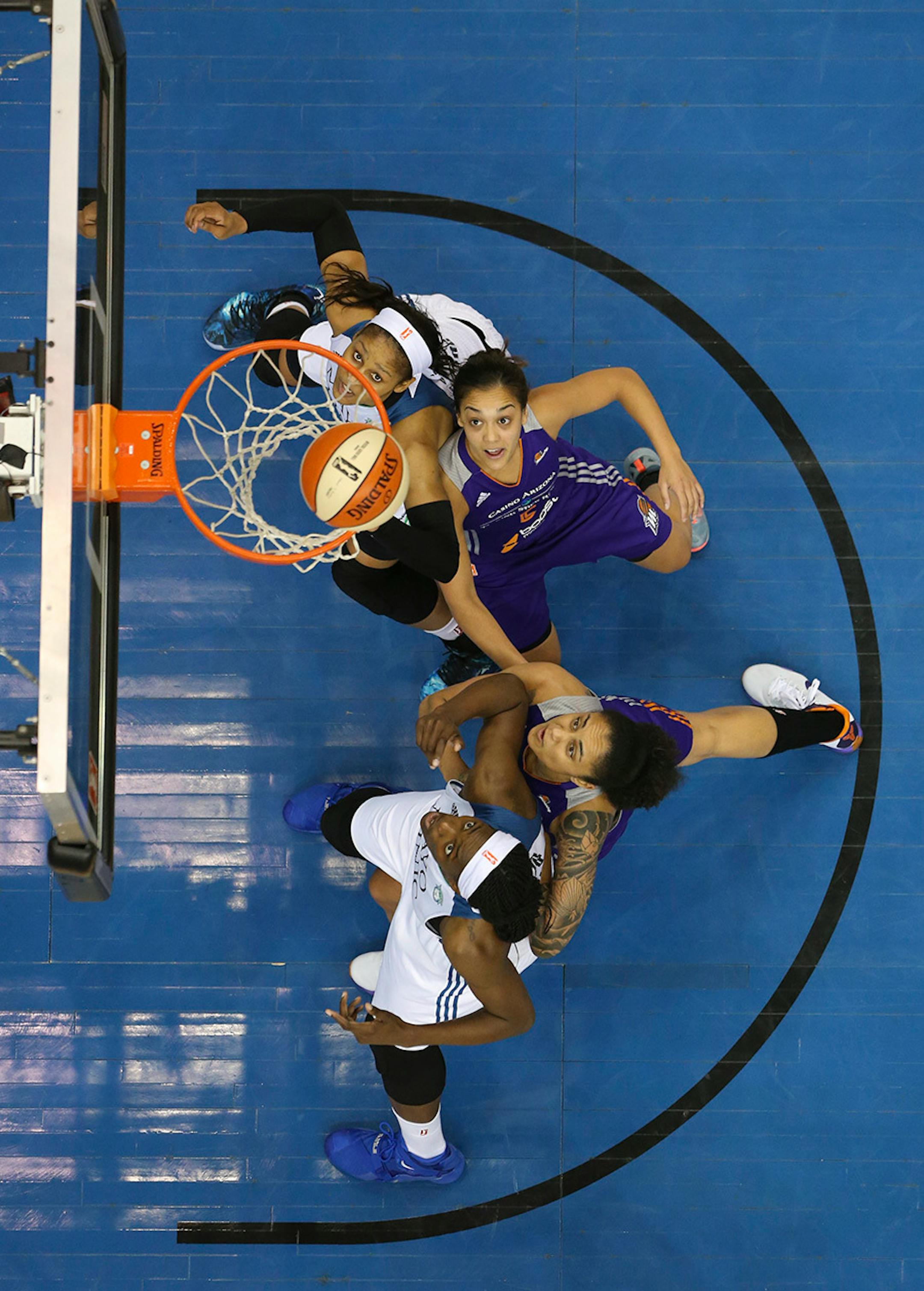 Lynx forward Maya Moore (23), top, and Lynx center Sylvia Fowles (34), bottom watched a first half shot drop Thursday night at Target Center. Defending were Phoenix Mercury forward Mistie Bass (8) and Phoenix Mercury forward Candice Dupree (4).