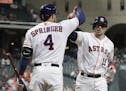 Houston Astros' Jason Castro (15) is congratulated by George Springer (4) after hitting a home run against the Texas Rangers during the sixth inning o