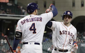 Houston Astros' Jason Castro (15) is congratulated by George Springer (4) after hitting a home run against the Texas Rangers during the sixth inning o