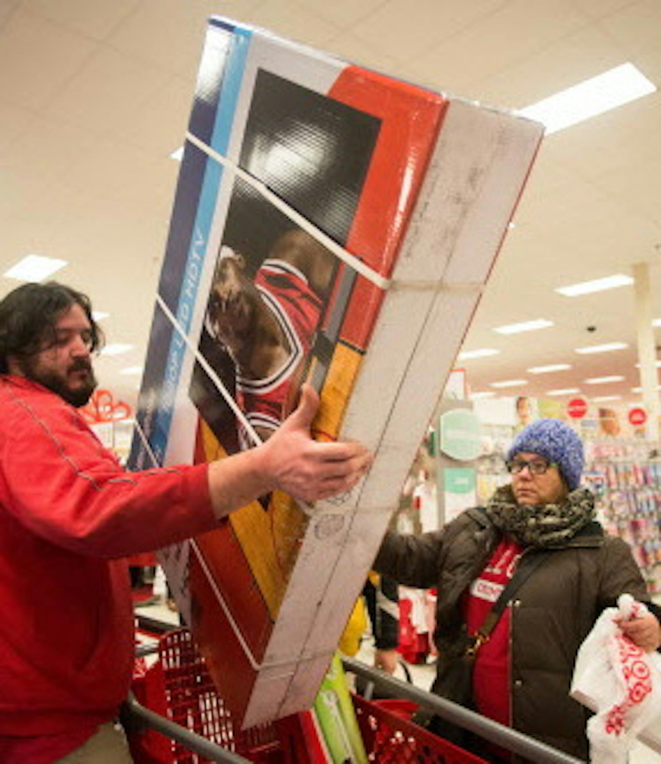 Super Target employee Jeremy Streit helps lift a big screen television into the cart of Tonii Simmons during Thanksgiving night shopping. ] AARON LAVINSKY • aaron.lavinsky@startribune.com Black Friday got an earlier kick off this year on Thanksgiving Day. Shoppers lined up early to be the first to get big deals on their holiday shopping at Target in Roseville Thursday, Nov. 27, 2014. ORG XMIT: MIN1411271928050009