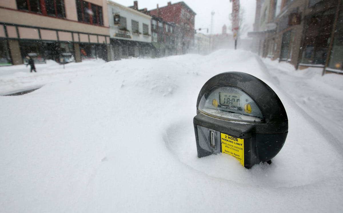 A parking meter pokes out of a snow bank during a blizzard, Saturday, Feb. 9, 2013, in Portland, Maine. The storm dumped more than 30 inches of snow a